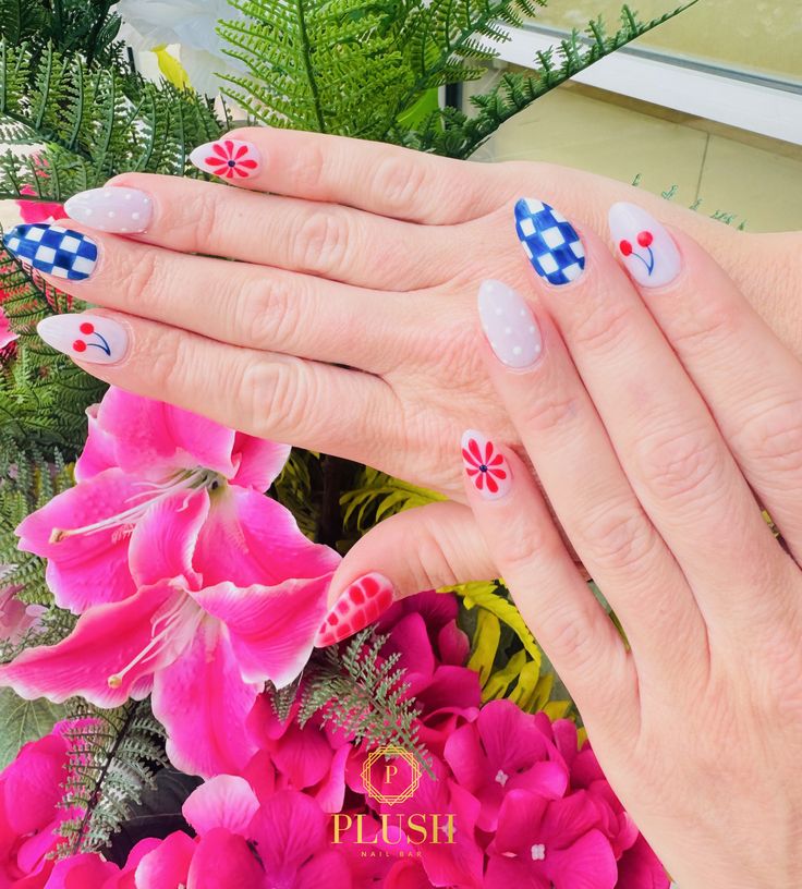 4th of July nail design featuring red and blue gingham patterns, cherry nail art, red floral accents, and soft white polka dot nails on a milky base. This playful and cute fourth of July nail idea combines classic patriotic colors with trendy summer nail art. A fun take on simple 4th of July nails, perfect for floral nail lovers looking for July 4 nail inspiration, patriotic manicures, and unique red, white, and blue nail designs.