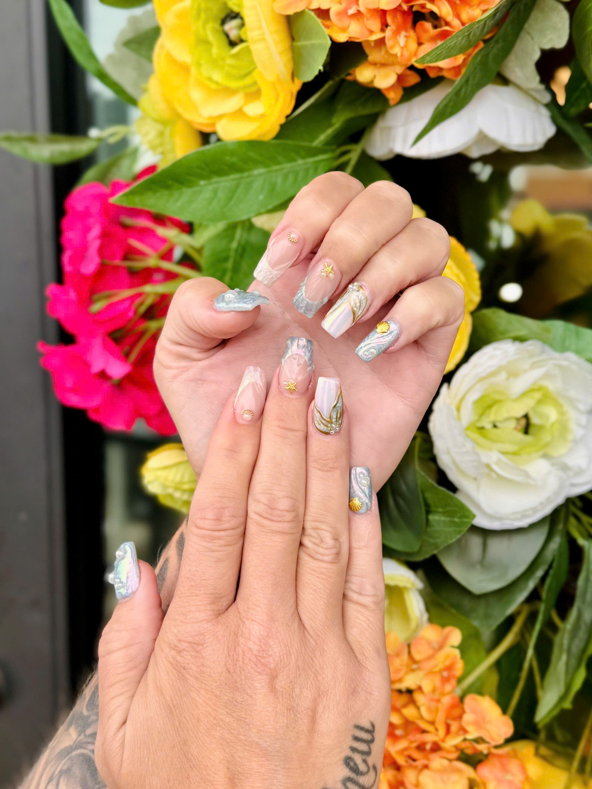 3D ocean marble nails with seashell and starfish designs, featuring silver-blue tones, gold accents, and 3D nail art textures for a stylish summer look.
