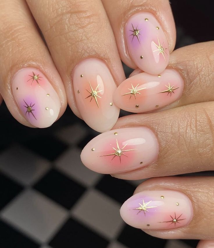 Subtle 4th of July nail design featuring pink and purple ombre nails with gold starburst decals and tiny metallic dots. This elegant and classy 4th of July manicure blends soft gradient tones with patriotic sparkle, making it ideal for July nail ideas, minimal patriotic nails, or festive nail art with a delicate touch. Perfect for those seeking a chic, feminine take on 4th of July nails without bold red, white, and blue.