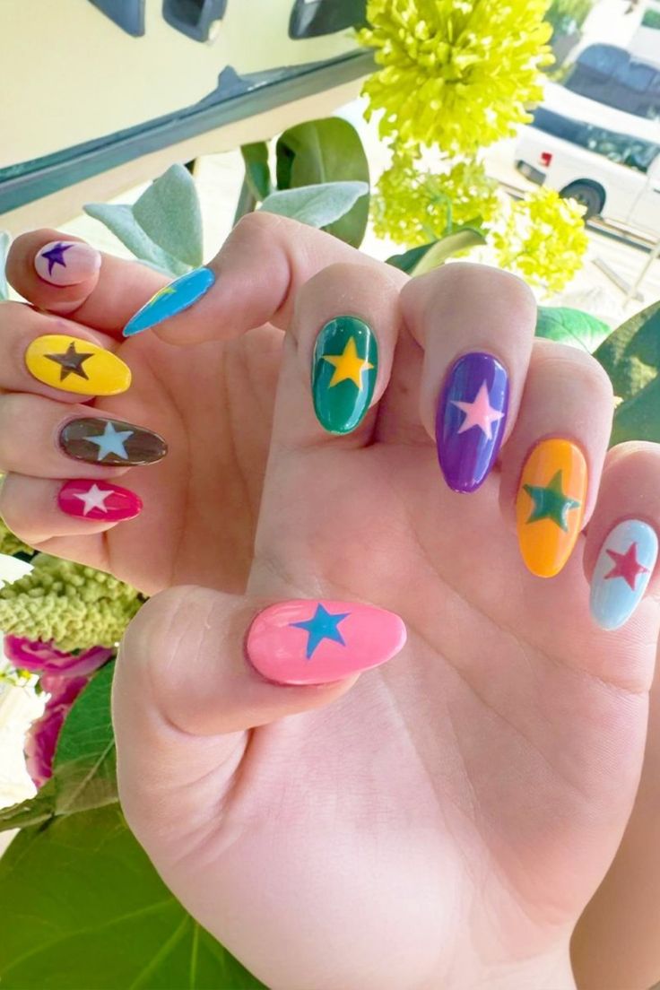 Colorful star nail art with a playful mix of vibrant shades like pink, yellow, purple, green, blue, and orange, each featuring a bold star in the center. This bright and fun design is perfect for cute 4th of July nails, July nail ideas, and patriotic nail art with a modern twist. Ideal for summer celebrations and festive manicures, this unique 4th of July nail design blends creativity and color beyond traditional red, white, and blue. A bold take on 4th of July nails for those who love expressive, standout styles.